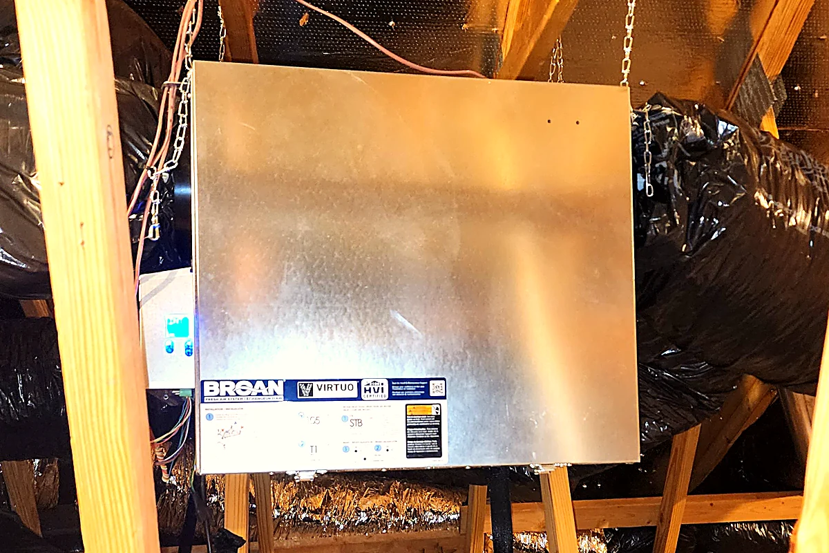 Broan Virtuo energy recovery ventilator hung from attic rafters and tied into insulated ductwork in a Triangle NC home